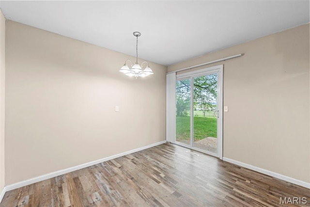 210 Scenic Dr, Elsberry, MO 63343 - spare room featuring baseboards, wood finished floors, and a chandelier
