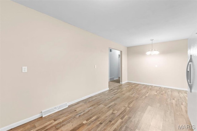 210 Scenic Dr, Elsberry, MO 63343 - spare room with a chandelier, light wood-style floors, and baseboards