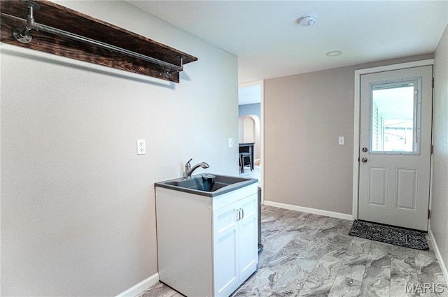 415 W James Blvd, St James, MO 65559 - kitchen featuring a sink, white cabinets, light marble finish flooring, and baseboards