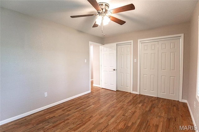 415 W James Blvd, St James, MO 65559 - unfurnished bedroom with wood finished floors, baseboards, multiple closets, and ceiling fan