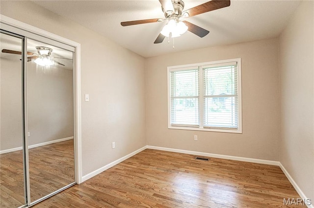 415 W James Blvd, St James, MO 65559 - unfurnished bedroom with wood finished floors, a closet, baseboards, and ceiling fan