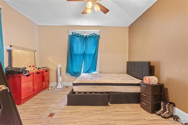 bedroom featuring a ceiling fan, light wood-style floors, and baseboards