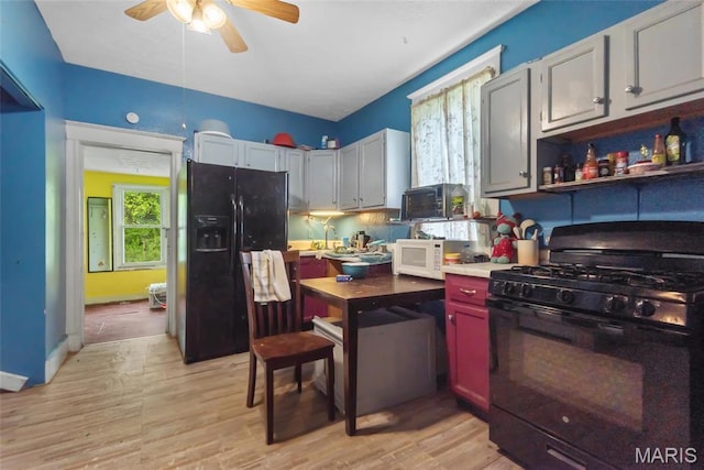 kitchen with black appliances, a ceiling fan, light wood finished floors, light countertops, and open shelves