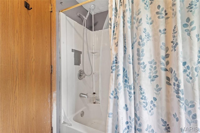 bathroom with shower / bath combo with shower curtain and a textured ceiling