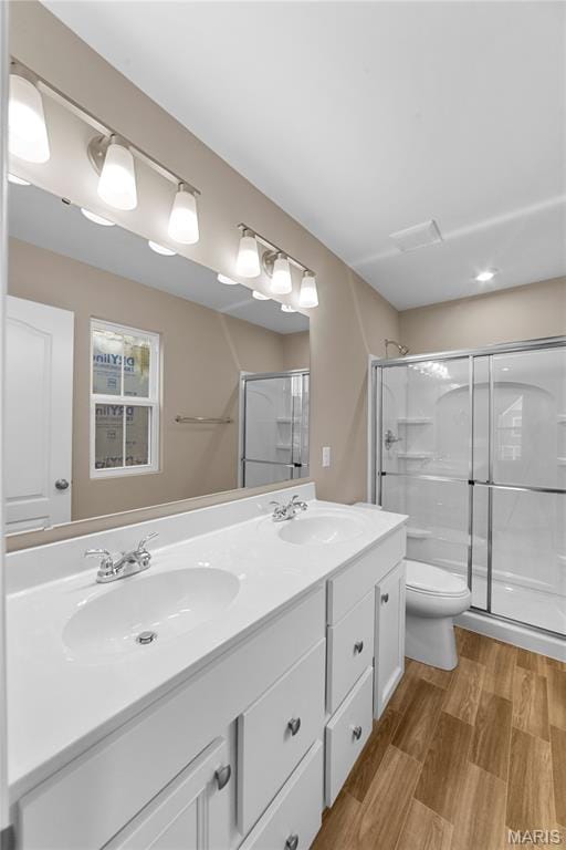 317 Newbridge Way, Ofallon, MO 63368 - full bath featuring double vanity, toilet, a shower stall, and wood finished floors