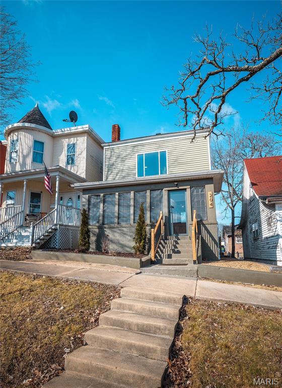 204 S 3rd St, De Soto, MO 63020 - view of front facade with a chimney, a porch, and stairs