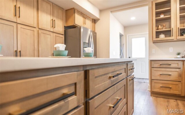 204 S 3rd St, De Soto, MO 63020 - kitchen with stainless steel fridge, glass insert cabinets, wood finished floors, recessed lighting, and light brown cabinets