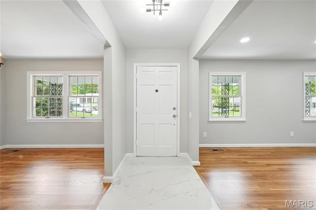 foyer entrance with baseboards, wood finished floors, and recessed lighting