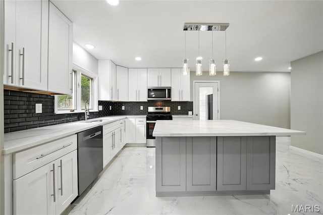 kitchen featuring stainless steel appliances, a sink, light marble finish floors, backsplash, and a center island