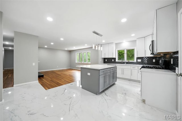 kitchen featuring healthy amount of natural light, recessed lighting, tasteful backsplash, white cabinetry, and stainless steel microwave