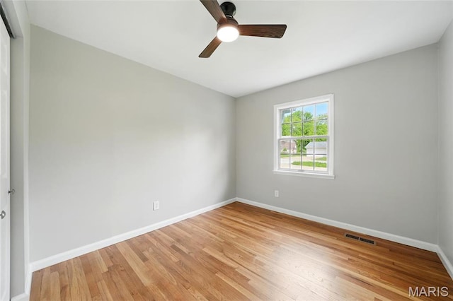 unfurnished room with baseboards, light wood-style floors, and a ceiling fan
