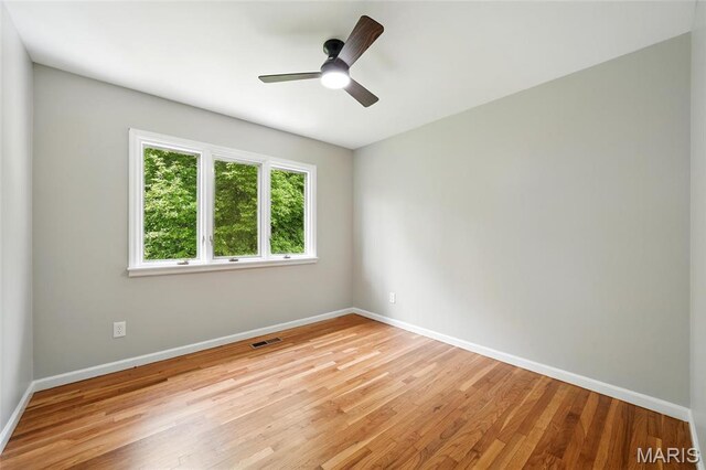 unfurnished room with baseboards, light wood-type flooring, and a ceiling fan