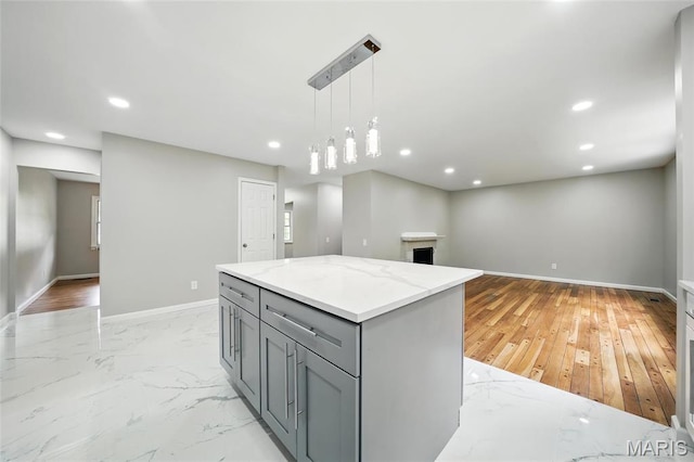 kitchen with gray cabinets, baseboards, recessed lighting, light stone countertops, and pendant lighting