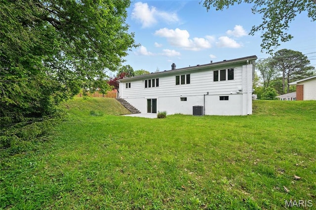 rear view of property with stairs, a yard, and central air condition unit