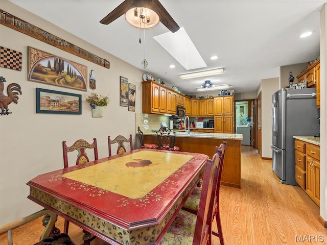 2700 Woods Way, Belleville, IL 62221 - dining space featuring light wood-type flooring, a ceiling fan, a skylight, recessed lighting, and washer / dryer