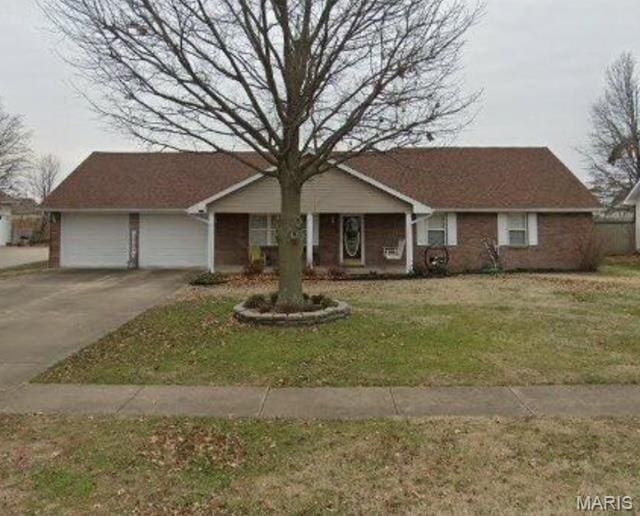 ranch-style home with concrete driveway, a front lawn, and an attached garage