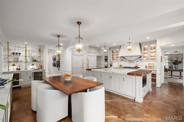 20 Picardy Ln, Ladue, MO 63124 - kitchen featuring butcher block countertops, a kitchen island, wine cooler, ornamental molding, and recessed lighting