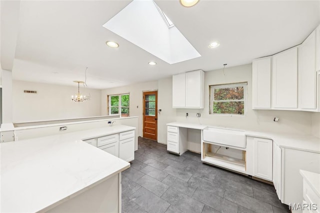 18 Spoede Hills Dr, Saint Louis, MO 63141 - kitchen with white cabinetry, recessed lighting, light countertops, a chandelier, and a skylight