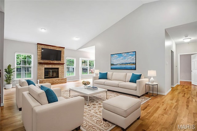 1587 Paradise Valley Dr, High Ridge, MO 63049 - living area featuring light wood finished floors, a brick fireplace, and high vaulted ceiling