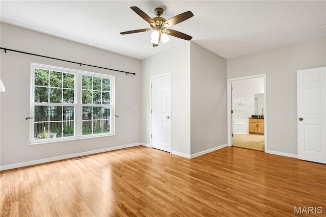 1587 Paradise Valley Dr, High Ridge, MO 63049 - unfurnished bedroom featuring light wood-style flooring, ensuite bathroom, and a ceiling fan