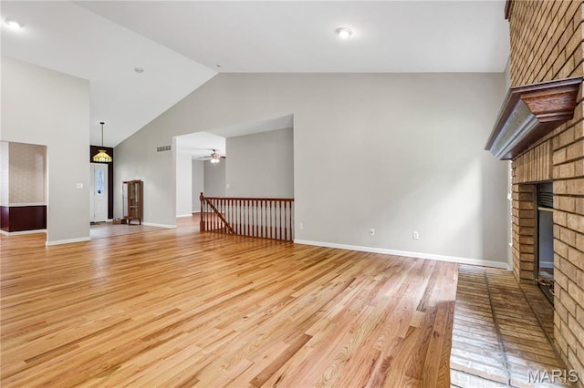 1587 Paradise Valley Dr, High Ridge, MO 63049 - unfurnished living room with a brick fireplace, light wood finished floors, a ceiling fan, and high vaulted ceiling