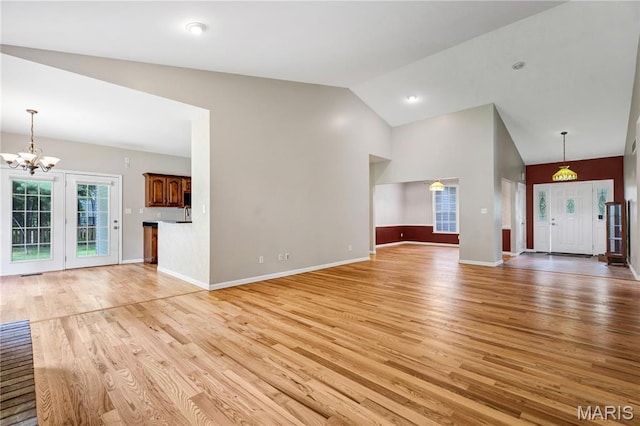 1587 Paradise Valley Dr, High Ridge, MO 63049 - unfurnished living room featuring light wood-style floors, a chandelier, and high vaulted ceiling
