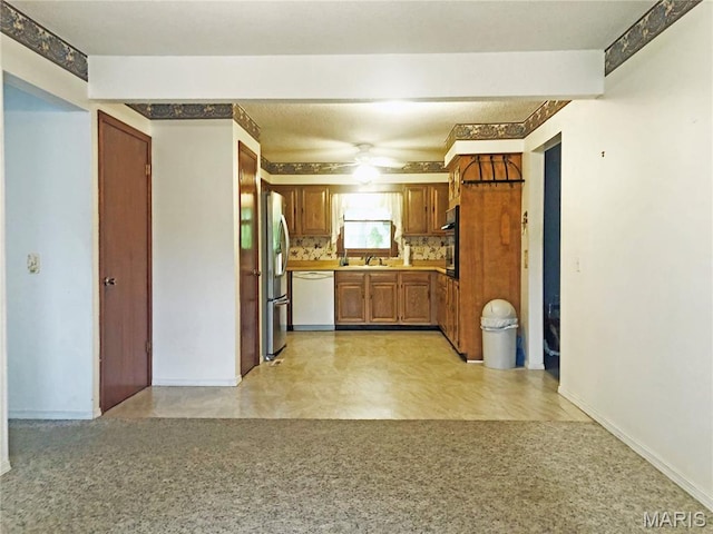 603 W Bloomfield Ave, Bloomfield, MO 63825 - kitchen with white dishwasher, stainless steel fridge with ice dispenser, a sink, light carpet, and brown cabinets