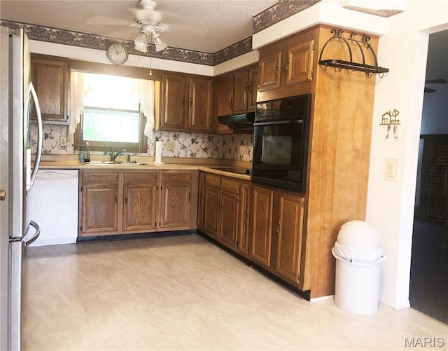 603 W Bloomfield Ave, Bloomfield, MO 63825 - kitchen featuring black appliances, a ceiling fan, light countertops, a sink, and under cabinet range hood