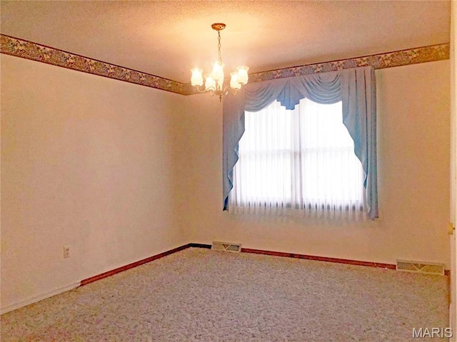 603 W Bloomfield Ave, Bloomfield, MO 63825 - carpeted empty room featuring a chandelier, a textured ceiling, and baseboards