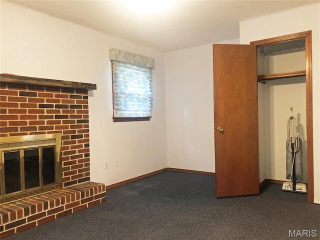 603 W Bloomfield Ave, Bloomfield, MO 63825 - unfurnished living room featuring dark colored carpet, a brick fireplace, and baseboards