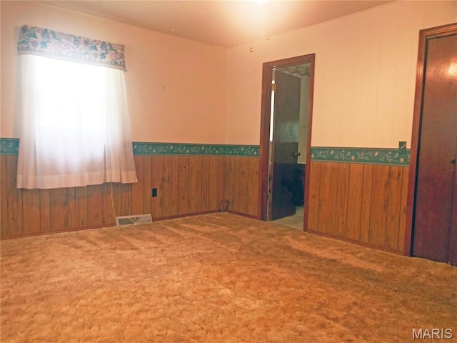 603 W Bloomfield Ave, Bloomfield, MO 63825 - carpeted spare room with wainscoting and wood walls