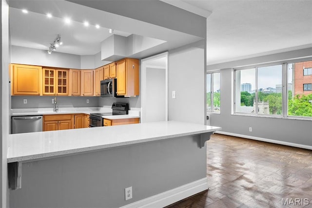 900 S Hanley Rd Unit 7B, Saint Louis, MO 63105 - kitchen with appliances with stainless steel finishes, baseboards, a sink, glass insert cabinets, and track lighting