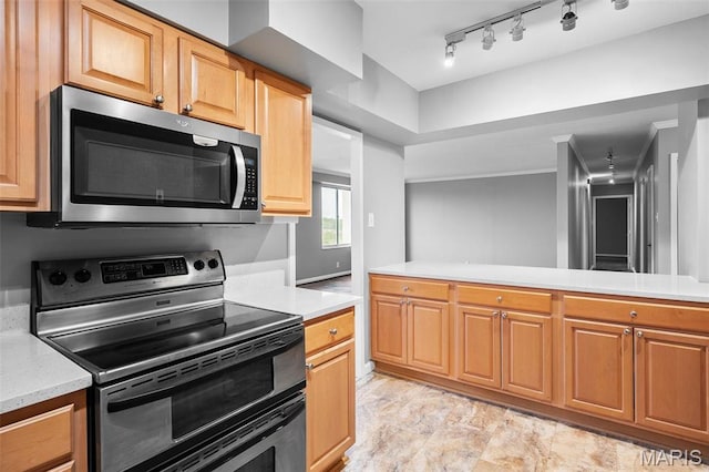 900 S Hanley Rd Unit 7B, Saint Louis, MO 63105 - kitchen featuring appliances with stainless steel finishes, light countertops, and rail lighting