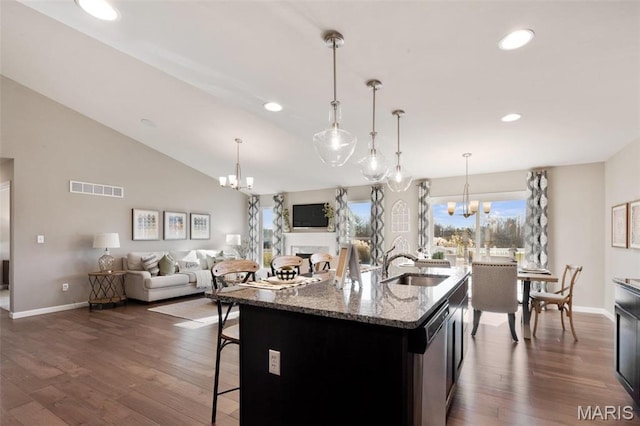4609 Siesta Dr, Imperial, MO 63052 - kitchen featuring a chandelier, dark wood-style floors, a breakfast bar area, open floor plan, and light stone counters