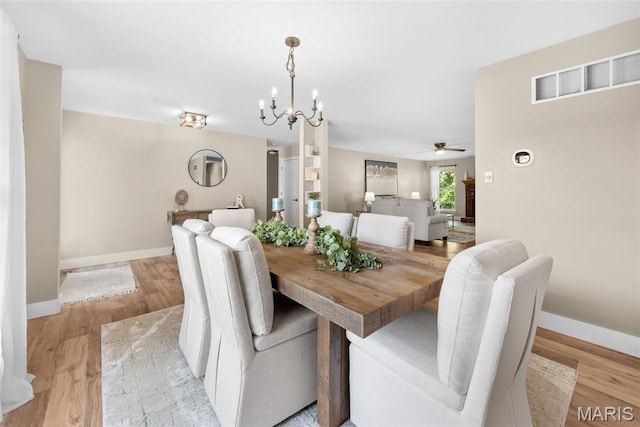2222 Harborside Dr, Ofallon, MO 63368 - dining space featuring baseboards, ceiling fan, a chandelier, and light wood finished floors