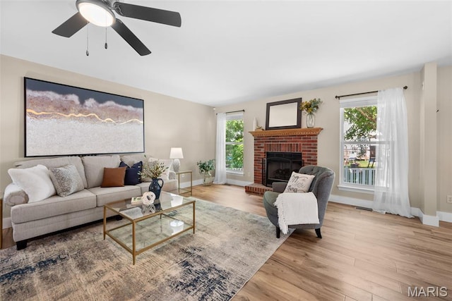 2222 Harborside Dr, Ofallon, MO 63368 - living area featuring wood finished floors, plenty of natural light, a brick fireplace, and baseboards