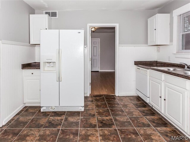 123 E Charter St, Troy, IL 62294 - kitchen with white appliances, dark countertops, white cabinets, a sink, and wainscoting
