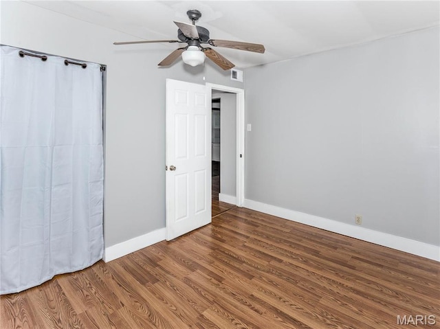 123 E Charter St, Troy, IL 62294 - unfurnished bedroom with wood finished floors, baseboards, and a ceiling fan