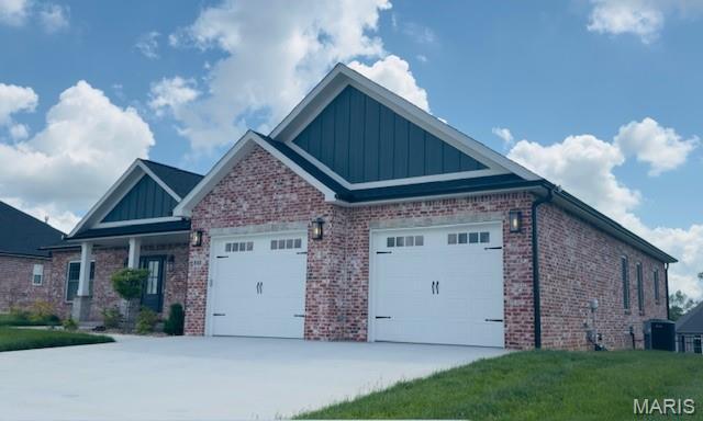 242 Orange Bowl Dr, Cape Girardeau, MO 63701 - view of side of property featuring board and batten siding, a garage, brick siding, and driveway