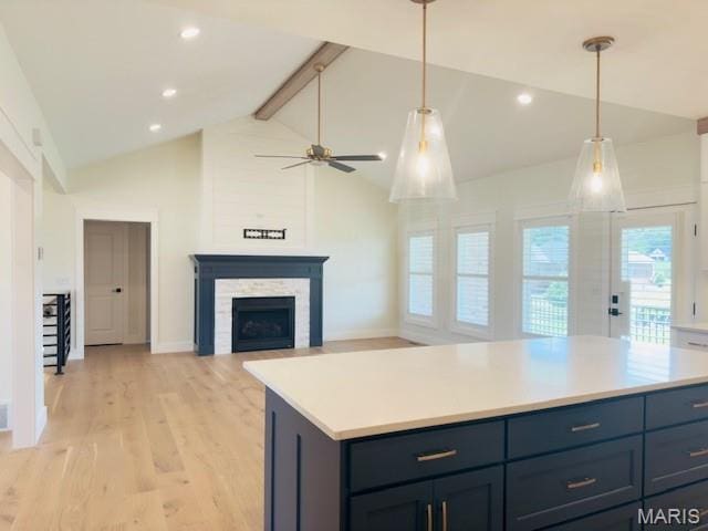 242 Orange Bowl Dr, Cape Girardeau, MO 63701 - kitchen featuring a fireplace, light wood-style flooring, light countertops, beam ceiling, and a ceiling fan