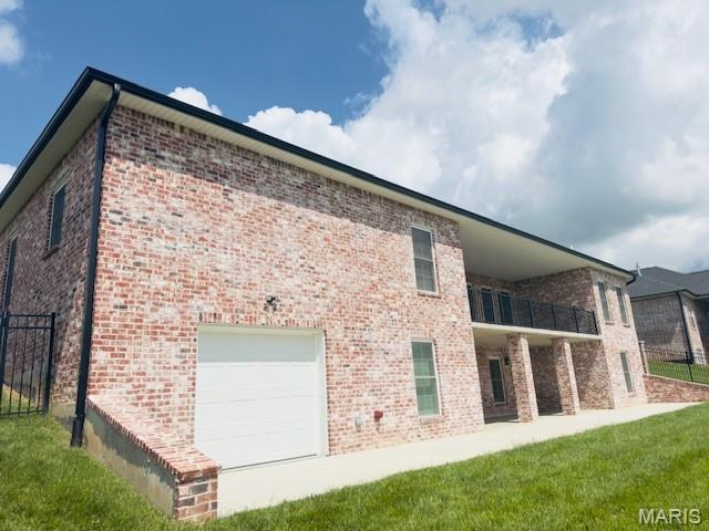 242 Orange Bowl Dr, Cape Girardeau, MO 63701 - view of property exterior featuring fence, brick siding, and a balcony