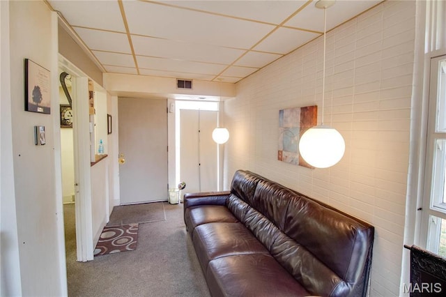 living room featuring carpet flooring and a paneled ceiling