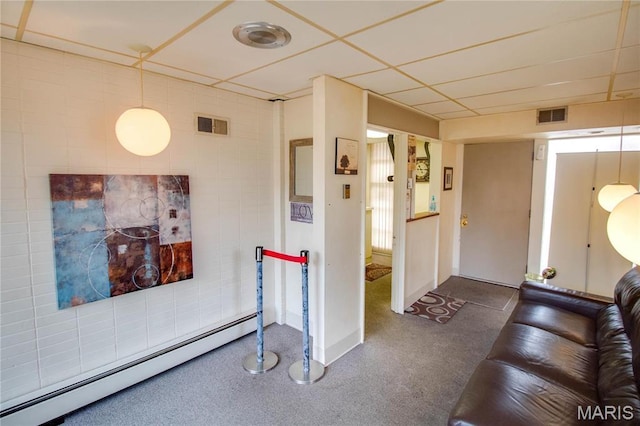 living area with a baseboard heating unit, baseboards, and a paneled ceiling