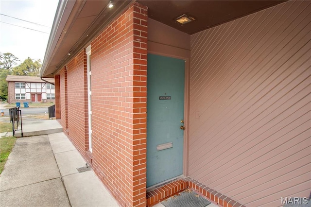 entrance to property featuring brick siding