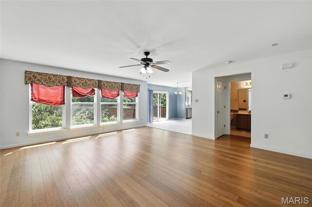 6144 Misty Meadow Dr, House Springs, MO 63051 - unfurnished living room featuring a ceiling fan, wood finished floors, and a chandelier