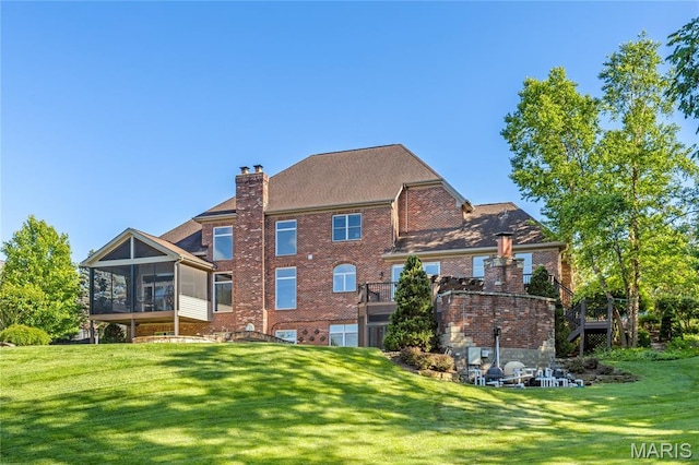 13815 Clayton Rd, Chesterfield, MO 63017 - rear view of house featuring a sunroom, a lawn, a chimney, and brick siding