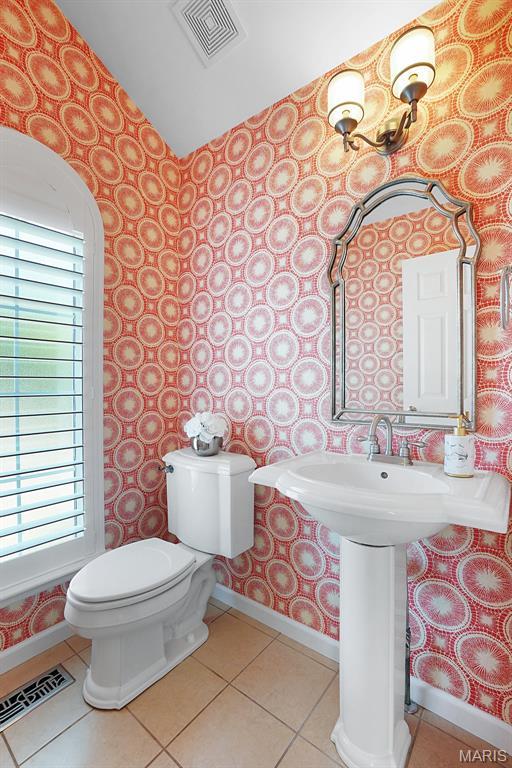 385 E Clinton Pl, Saint Louis, MO 63122 - half bathroom with wallpapered walls, toilet, baseboards, lofted ceiling, and tile patterned floors
