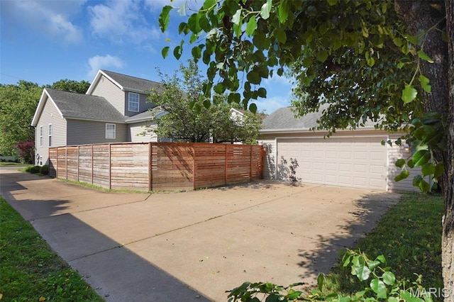 385 E Clinton Pl, Saint Louis, MO 63122 - view of side of property with fence, concrete driveway, and an attached garage