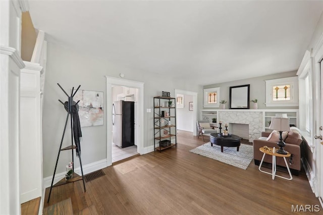 4942 Bonita Ave, Saint Louis, MO 63109 - living area with wood finished floors, baseboards, and a fireplace