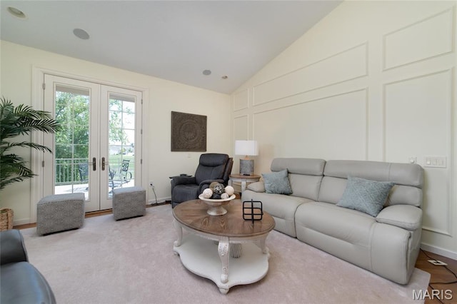 living room featuring french doors, lofted ceiling, and carpet floors